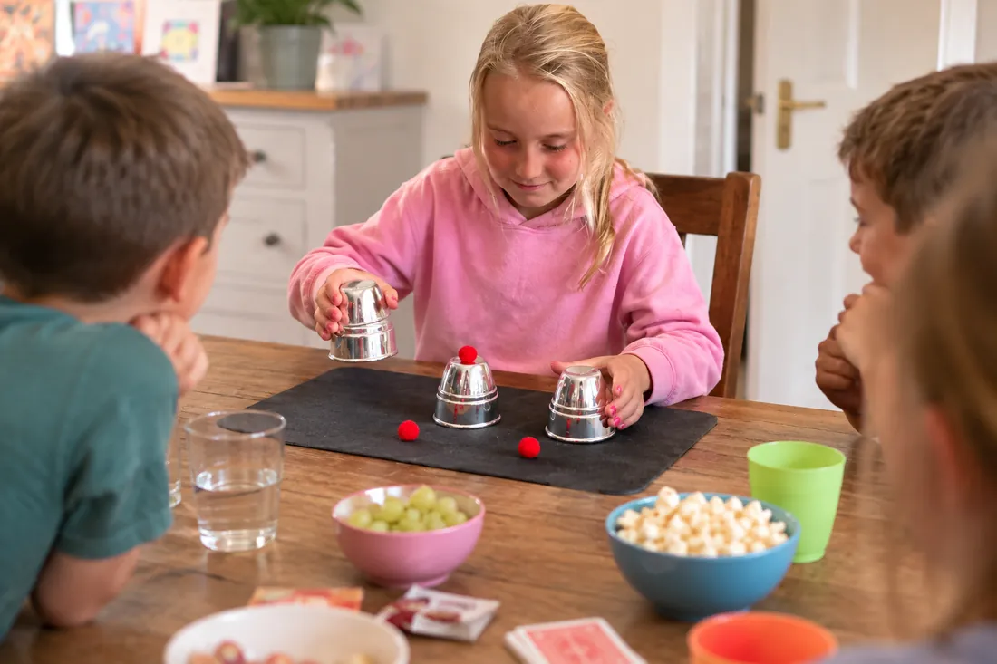 Children learning the cups and balls at a magic workshop party