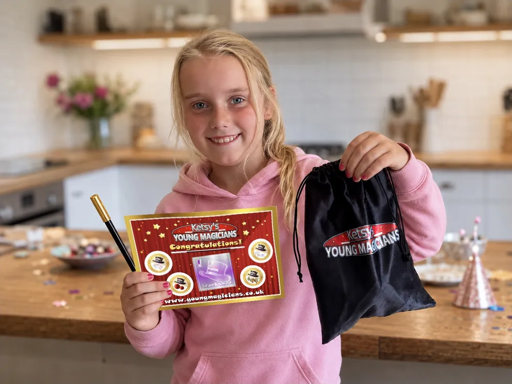 Girl holding her certificate, gold magic wand and velvet party bag