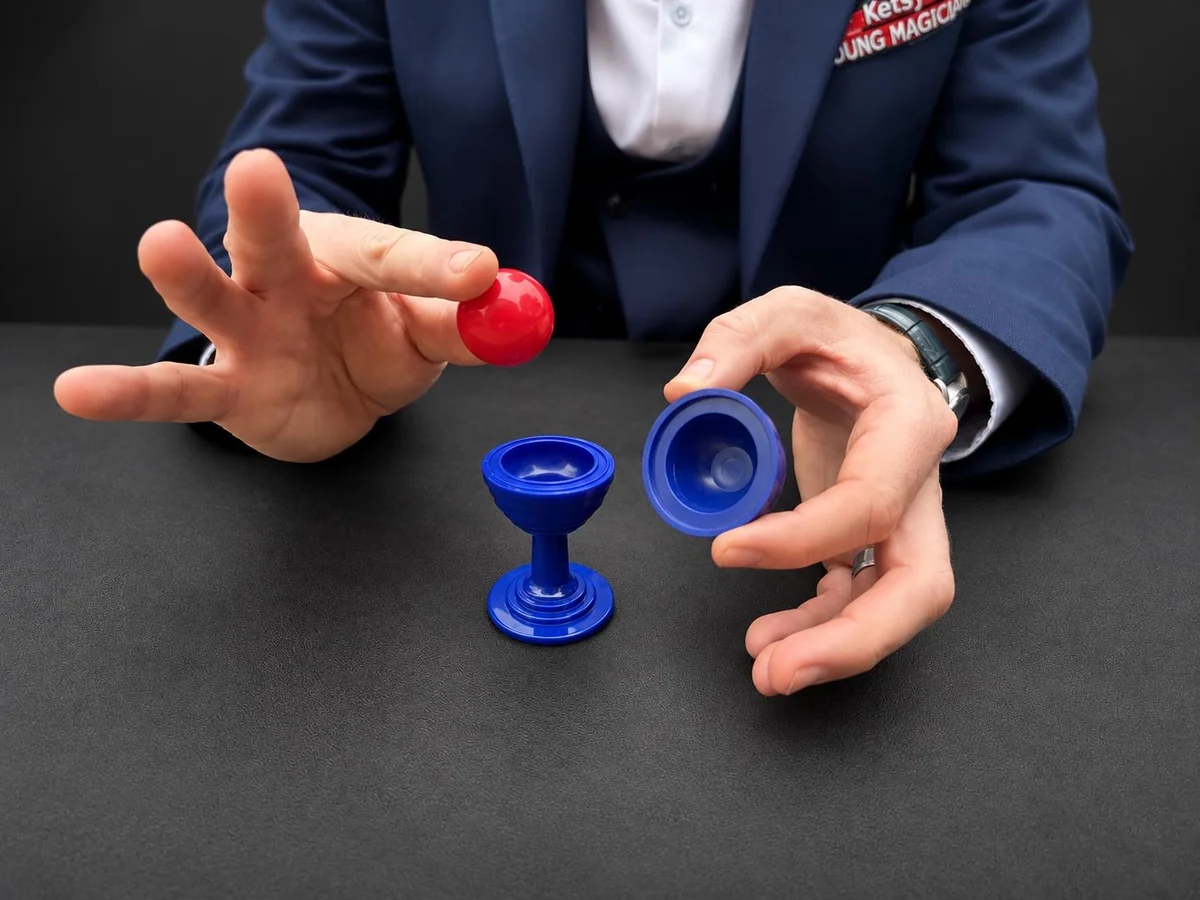 A magician performing the blue ball and vase trick