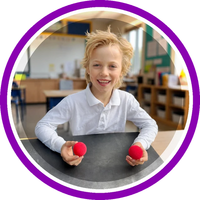 Boy holding two red sponge balls after learning the trick